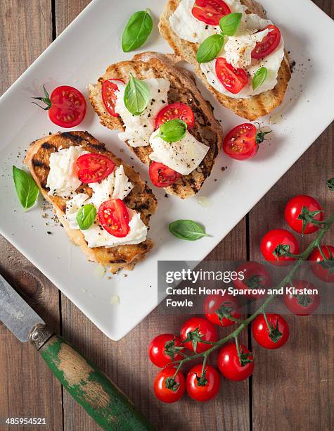 mozzarella, tomato and basil on bruschetta - mozzarella stock-fotos und bilder