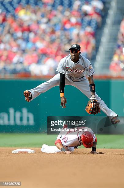 Dee Gordon of the Miami Marlins jumps over Ian Desmond of the Washington Nationals after completing a double play in the fourth inning at Nationals...