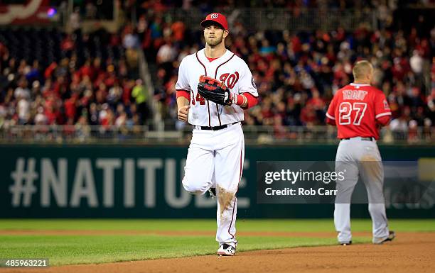 Bryce Harper of the Washington Nationals jogs past Mike Trout of the Los Angeles Angels after Trout lined out for the third out of the seventh inning...