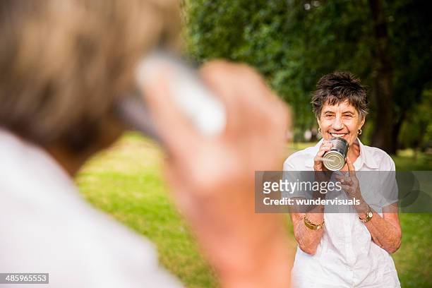 eldery communication concept - listening tin can stock pictures, royalty-free photos & images