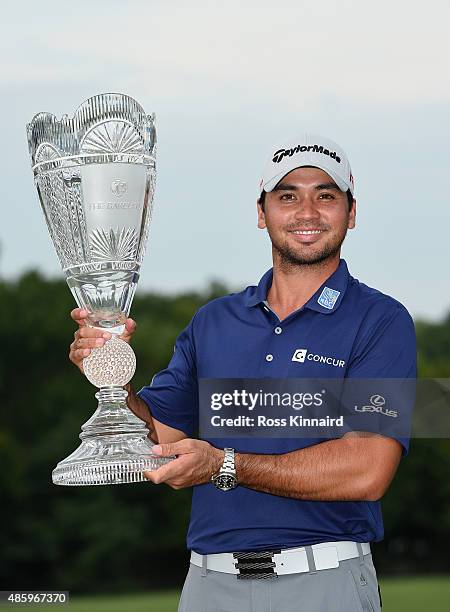 Jason Day of Australia poses with the winner's trophy on the 18th green after his six-stroke victory at The Barclays at Plainfield Country Club on...