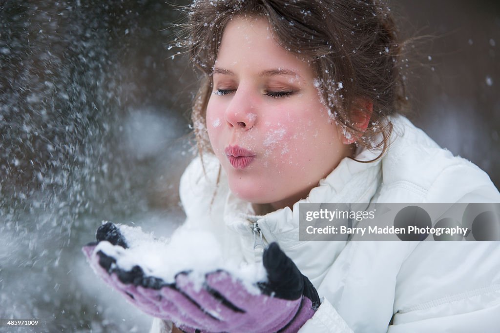 Portrait of teenager blowing snow from gloves