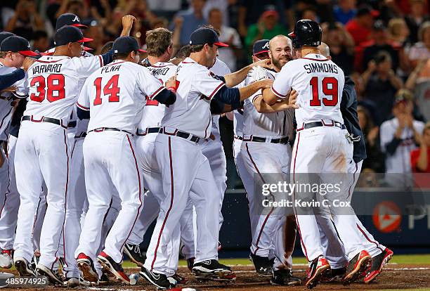 Evan Gattis of the Atlanta Braves celebrates with his teammates after hitting a walk-off homer in the tenth inning that scored Dan Uggla in their 4-2...