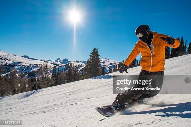 snowboarder cranks turn on mountain slope - snowboard stock-fotos und bilder