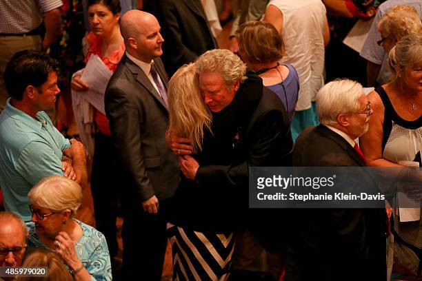 Andy Parker, father of Alison Parker, is comforted by a family member of Parker's boyfriend and colleague, Chris Hurst, following the Interfaith...