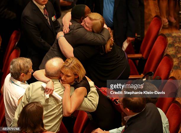 Kimberly McBroom, a morning anchor for WDBJ7, and Kelly Zuber, WDBJ7 news director, are hugged following the Interfaith Service of Remembrance and...