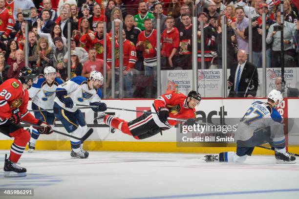 Michal Handzus of the Chicago Blackhawks shoots the puck toward an empty net, as Patrik Berglund of the St. Louis Blues reaches from behind, in Game...