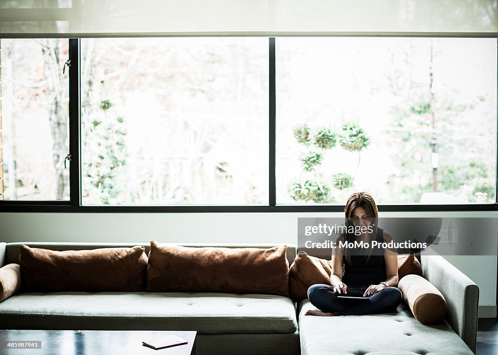 Woman using tablet on couch