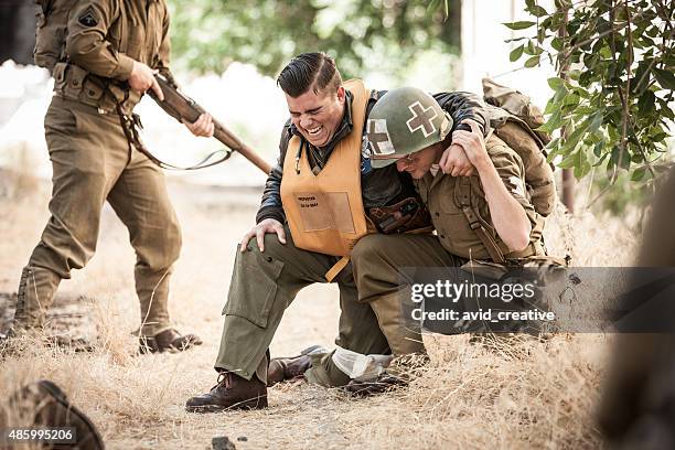 wwii medic helps wounded airman - wounded military stock pictures, royalty-free photos & images