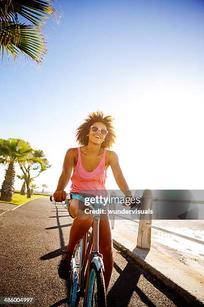 girl taking a seaside ride with bike - beach bike stock pictures, royalty-free photos & images