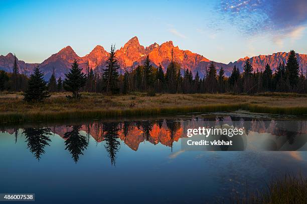 first light illuminating tetons mountain range - teton range stock pictures, royalty-free photos & images