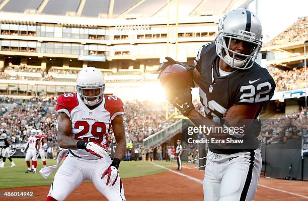 Taiwan Jones of the Oakland Raiders tries to catch the ball in the endzone while covered by Chris Clemons of the Arizona Cardinals at O.co Coliseum...