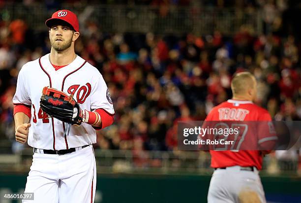 Bryce Harper of the Washington Nationals jogs past Mike Trout of the Los Angeles Angels after Trout lined out for the third out of the seventh inning...