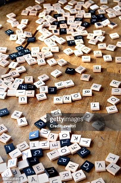 scrabble letter tiles on a wooden table - scrabble stock pictures, royalty-free photos & images