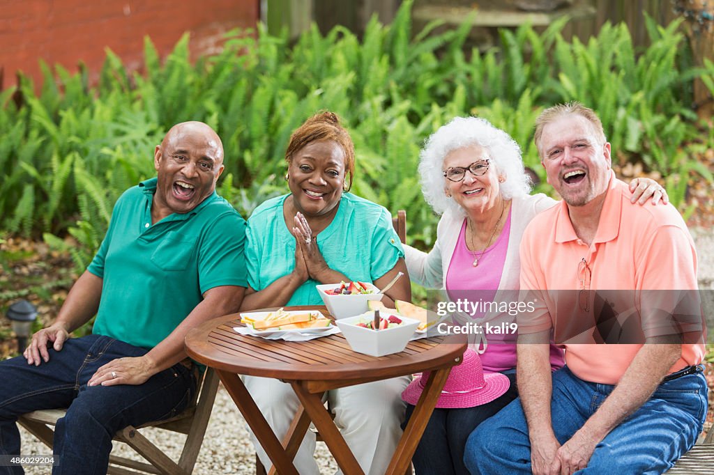 Group of seniors enjoying food and friends in back yard