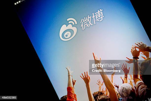 The landing page on Sina Corp.'s Sina Weibo microblogging service app is displayed on an Apple Inc. IPhone 5s in an arranged photograph in Hong Kong,...