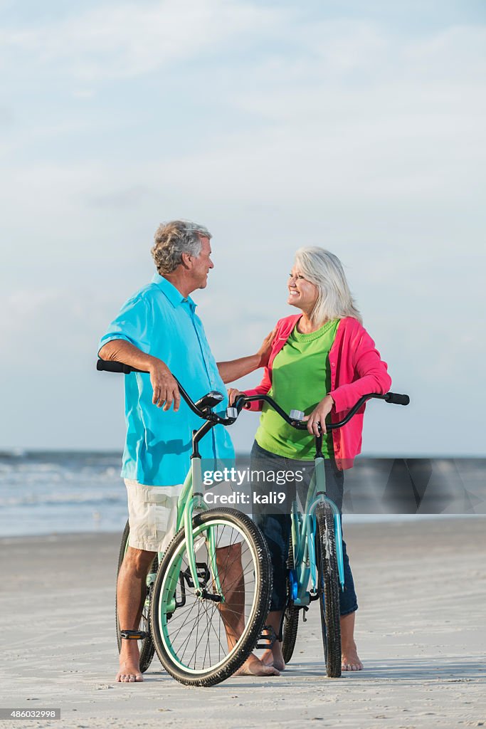 Mature couple with bicycles at the beach
