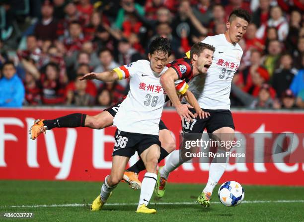 Shannon Cole of the Wanderers is tackled by Xiang Hantian and Yu Rui of Guizhou Renhe during the AFC Asian Champions League match between the Western...