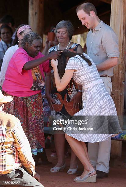 Catherine, Duchess of Cambridge is presented with a necklace and Prince William, Duke of Cambridge looks on at Uluru-Kata Tjuta Cultural Centre on...