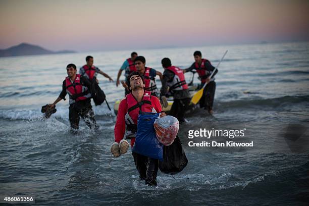 Migrants from Pakistan land on shore after completing a journey in a small dinghy crossing a three mile stretch of the Aegean Sea from Turkey August...