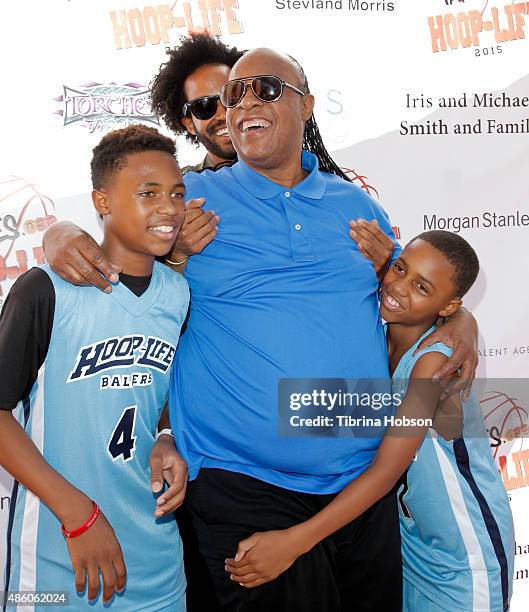 Kailand Morris, Kwame Morris and Mandla Morris lift their father, Stevie Wonder , on the red carpet at the 3rd annual Hoop-Life FriendRaiser at Galen...