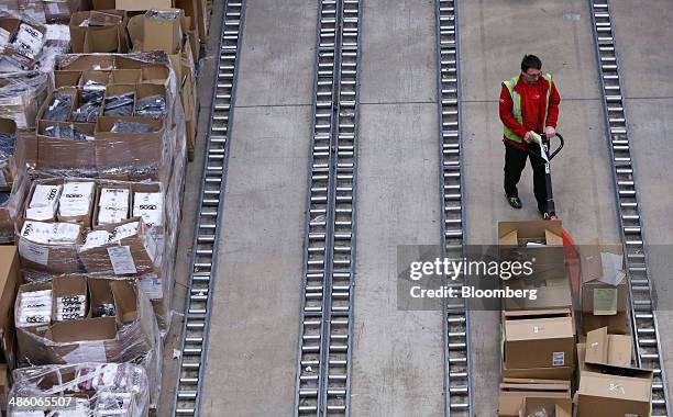 Worker uses a pallet truck to move boxes of clothes at the 'Goods Inwards' section inside Asos Plc's distribution warehouse in Barnsley, U.K., on...