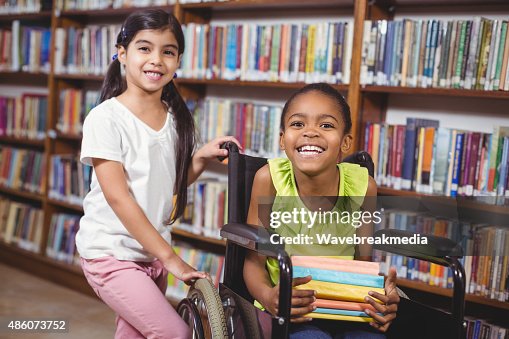 Smiling pupil in wheelchair holding books Smiling pupil in wheelchair holding books