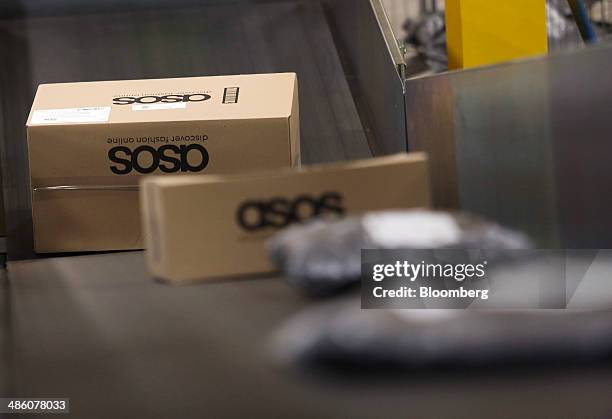 Boxed customer orders travel along a conveyor belt ahead of shipping at Asos Plc's distribution warehouse in Barnsley, U.K., on Tuesday, April 22,...