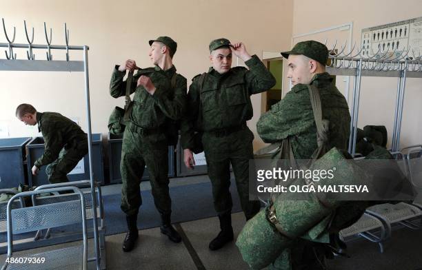 Russian army conscripts put on their uniform at the military registration and enlistment office in St. Petersburg, on April 22, 2014. Tens of...