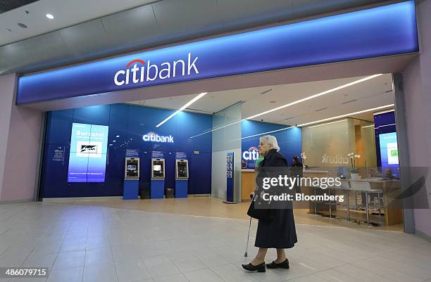 Pensioner passes automated teller machines inside a Citibank bank branch operated by Citigroup Inc. In Moscow, Russia, on Tuesday, April 22, 2014....