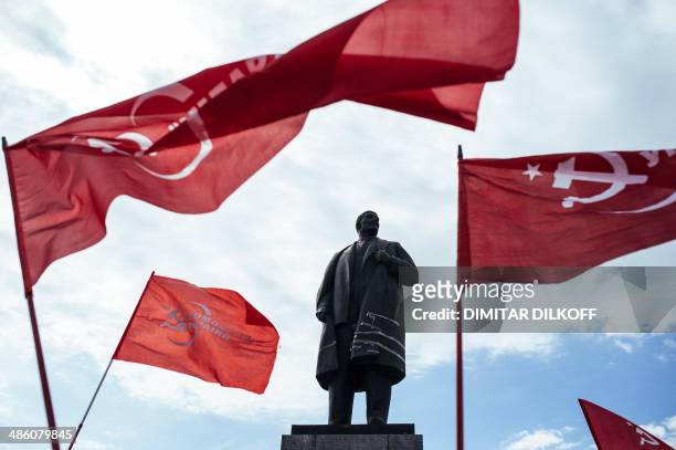 Supporters of the Ukrainian Communist Party wave red flags in front of a statue representing Soviet Union's founder Vladimir Lenin in the eastern...