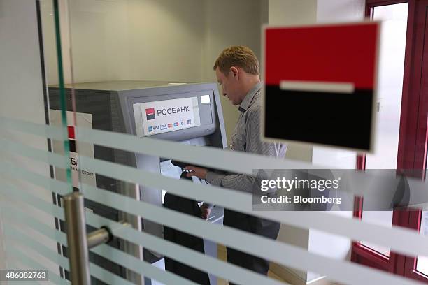 Customer uses an automated teller machine inside an OAO Rosbank bank branch, operated by Societe Generale Group, in Moscow, Russia, on Tuesday, April...