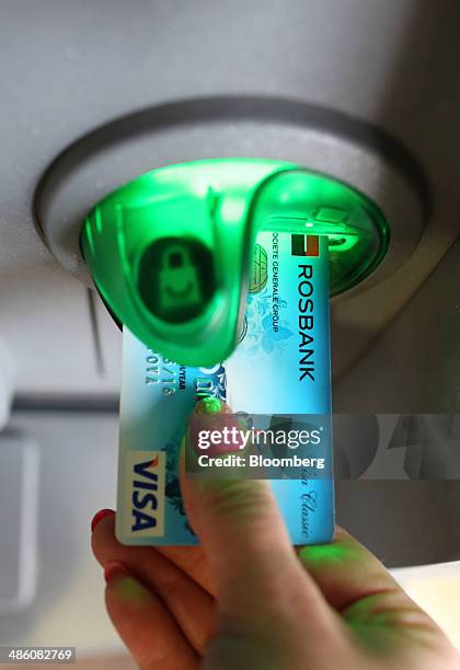 Customer uses a bank card marked with the Visa Inc. Logo at an automated teller machine inside an OAO Rosbank bank branch, operated by Societe...