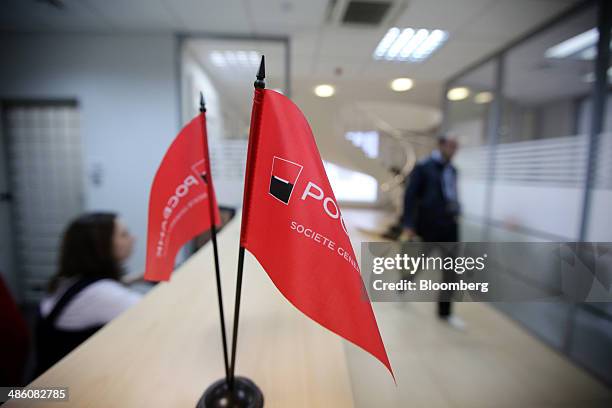 The logo of Societe Generale Group sits on mini flags at a service counter inside an OAO Rosbank bank branch in Moscow, Russia, on Tuesday, April 22,...