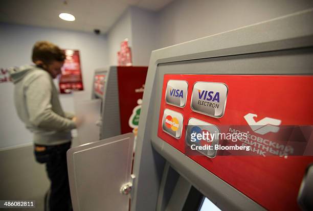 Logos for Visa Inc., Maestro and Mastercard Inc. Payment systems sit on an automated teller machine inside a Credit Bank of Moscow bank branch in...