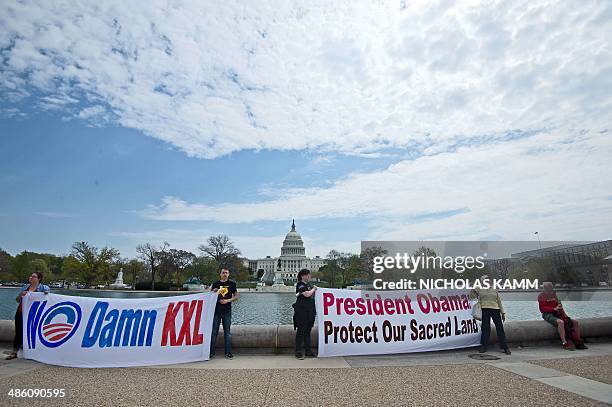 Members of the Cowboy and Indian Alliance hold signs at the Reflecting Pool in front of the US Capitol in Washington on April 22, 2014 as they...