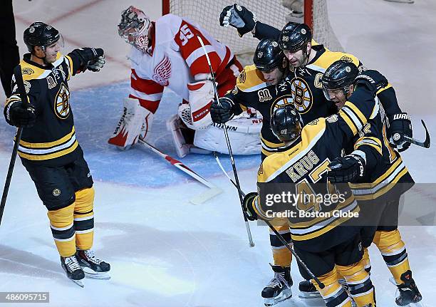 Bruins players, left to right, David Krejci, Milan Lucic, Torey Krug, Zdeno Chara, and Jarome Iginla gather in front of the Detroit goal to celebrate...