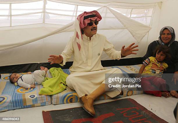 Saudi Prince Alwaleed bin Talal visits the tent of Syrian refugees who came from Idlib during his visit to Zaatari camp for Syrian refugees on April...