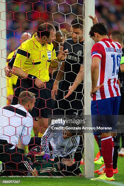 Diego Costa of Club Atletico de Madrid and Gary Cahill of Chelsea look on as Petr Cech of Chelsea receives treatment during the UEFA Champions League...