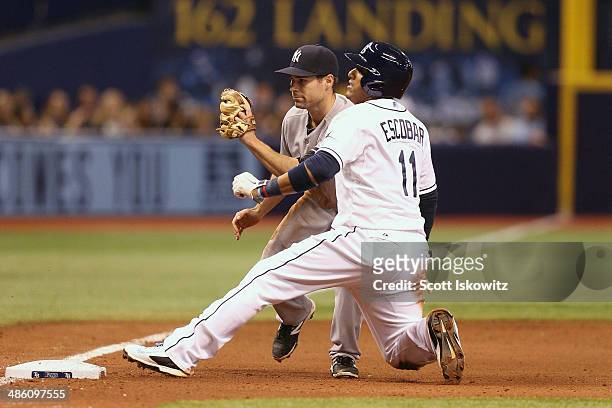 Yunel Escobar of the Tampa Bay Rays slides safely into third against Scott Sizemore of the New York Yankees at Tropicana Field on April 18, 2014 in...