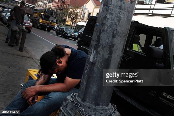 Passed out man sits along a sidewalk in an area which has witnessed an explosion in the use of K2 or 'Spice', a synthetic marijuana drug in East...
