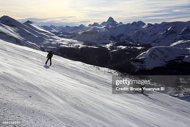 skiers on alpine ski slope - banff ski stock pictures, royalty-free photos & images