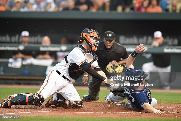 Logan Forsythe of the Tampa Bay Rays beats the tag by Caleb Joseph of the Baltimore Orioles on a fly ball sacrifice hit by Tim Beckham in the second...