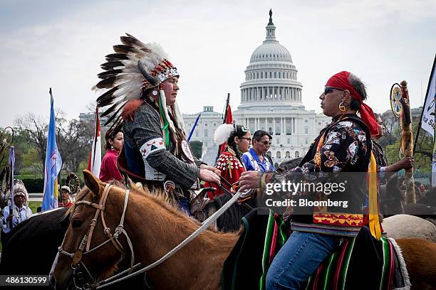 Members of the Cowboy and Indian Alliance , a group of ranchers, farmers and indigenous leaders, ride horses past the U.S. Capitol during a protest...