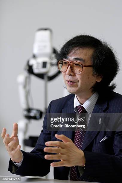 Yoshiyuki Sankai, founder and president of Cyberdyne Inc., speaks in front of the lower-limb model Hybrid Assistive Limb exoskeleton robot suit for...