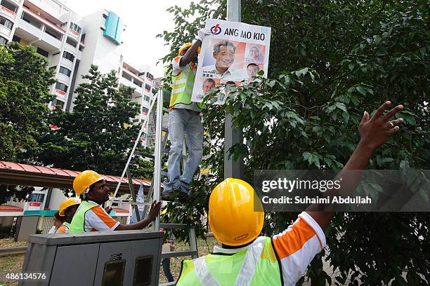 Workers put up party posters along the roadside after the nomination proceedings have been closed on September 1, 2015 in Singapore. Nomination day...