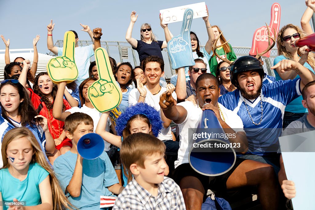 Football fans cheer for their team during sports event. Stadium.