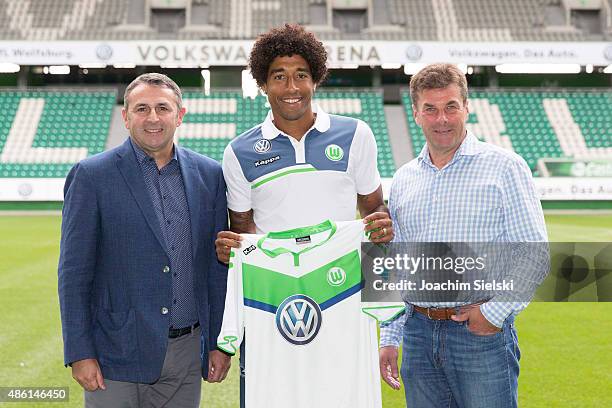 Klaus Allofs, Dante and Head Coach Dieter Hecking pose for photos on the pitch during a press conference at Volkswagen Arena on September 1, 2015 in...