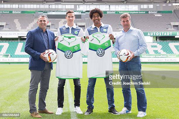 Klaus Allofs, Julian Draxler, Dante and Head Coach Dieter Hecking pose for photos on the pitch during a press conference at Volkswagen Arena on...