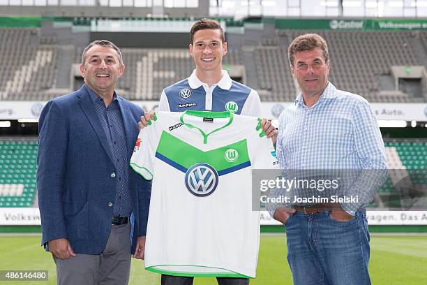 Klaus Allofs, Julian Draxler and Head Coach Dieter Hecking pose for photos on the pitch during a press conference at Volkswagen Arena on September 1,...